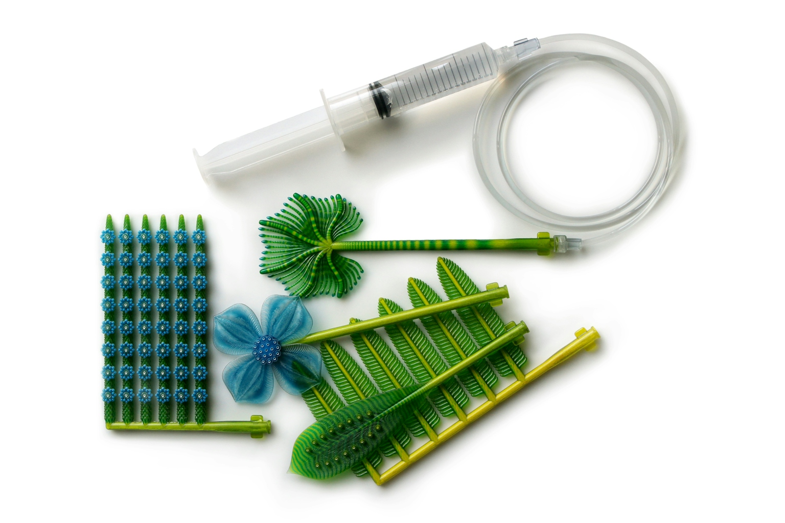 Top view of 3D printed plant-like forms with syringe and tubing.