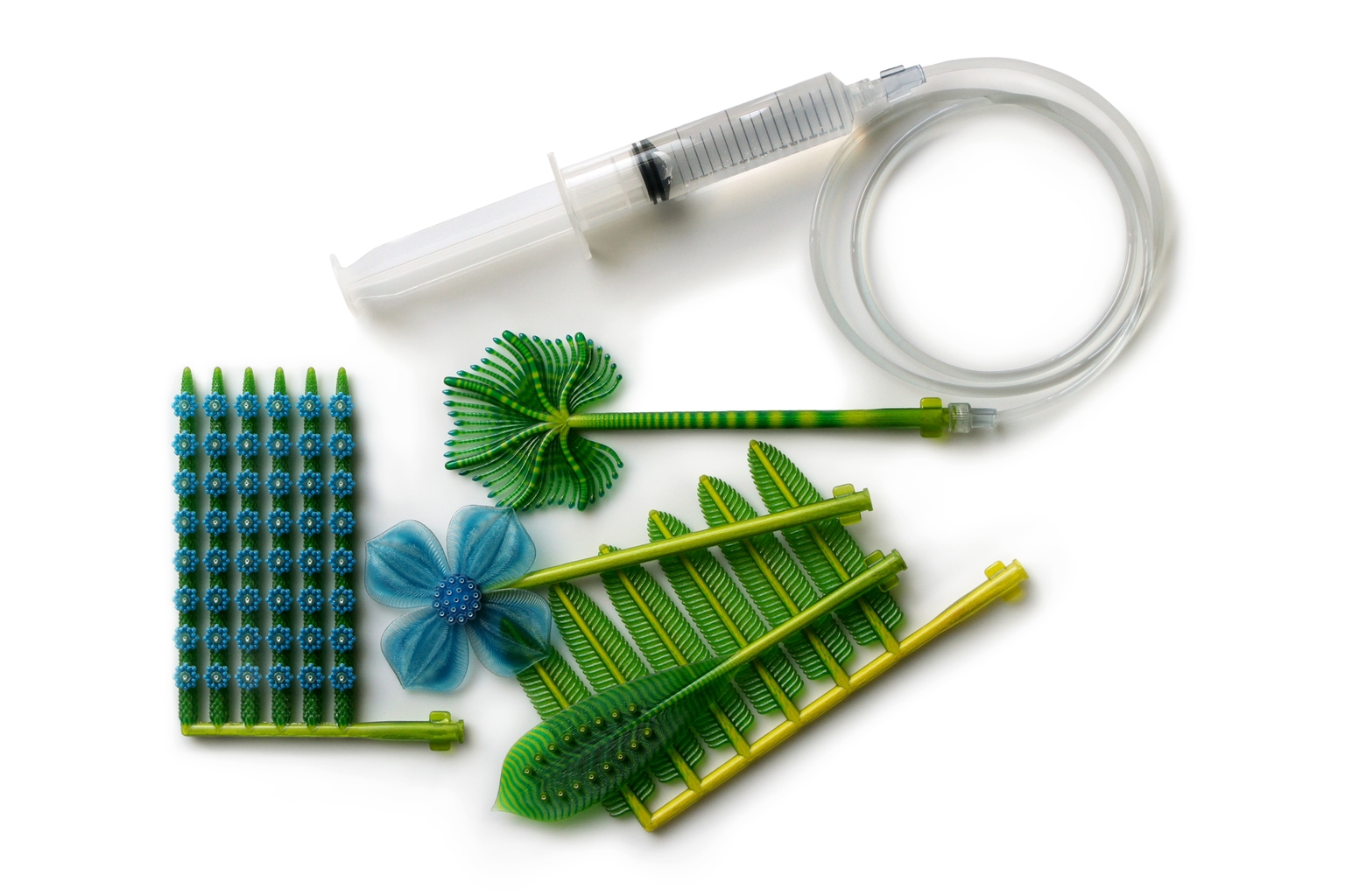 Top view of 3D printed plant-like forms with syringe and tubing.